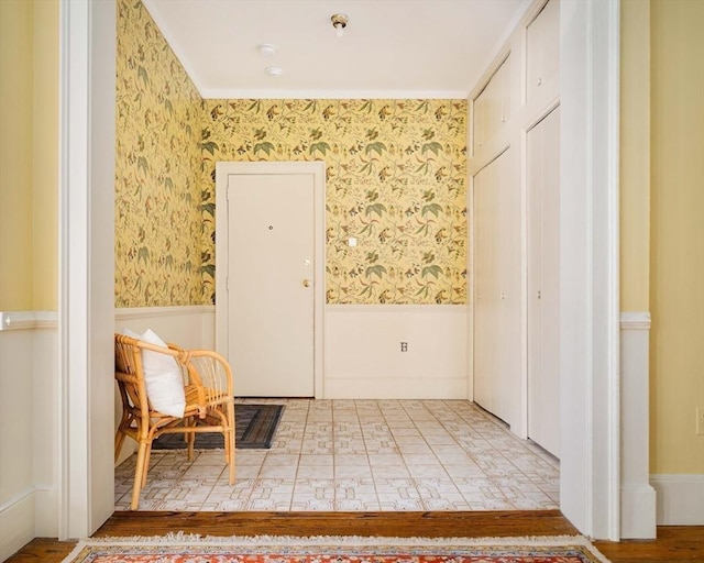 interior space featuring wainscoting and wallpapered walls