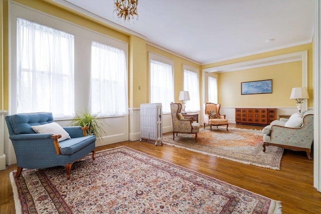 sitting room with baseboards, wood finished floors, and radiator heating unit