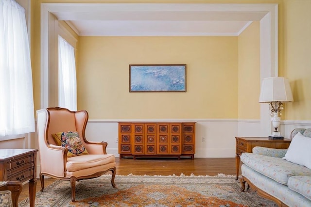 living area with plenty of natural light, wood finished floors, and crown molding