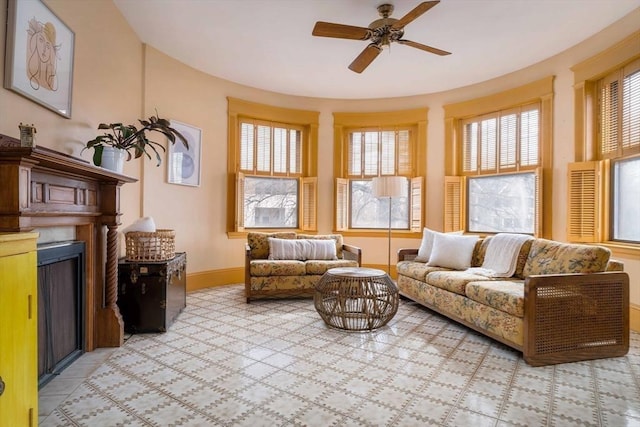 interior space with ceiling fan, a fireplace, and baseboards