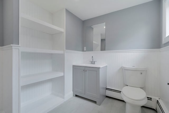 bathroom featuring a baseboard heating unit, vanity, and toilet