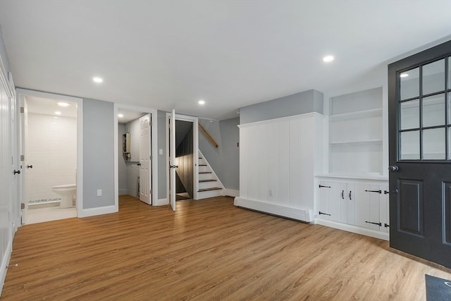 interior space featuring built in shelves and light hardwood / wood-style flooring