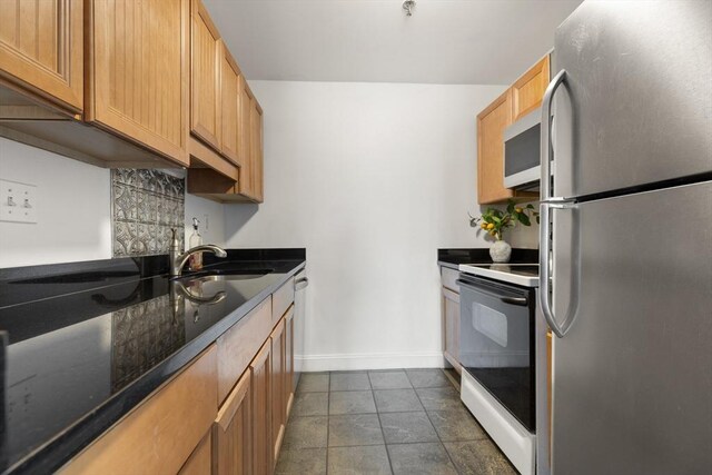 80 Wingate St Unit 3C, Haverhill, MA 01832 - kitchen with appliances with stainless steel finishes, a sink, tasteful backsplash, and baseboards
