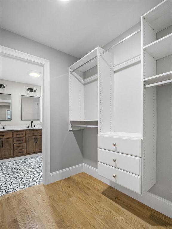 walk in closet featuring sink and light hardwood / wood-style floors