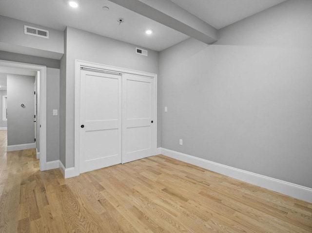 unfurnished bedroom with a closet and light hardwood / wood-style flooring