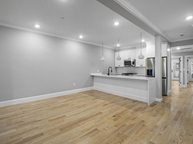 kitchen featuring light hardwood / wood-style flooring, white cabinets, decorative light fixtures, and appliances with stainless steel finishes