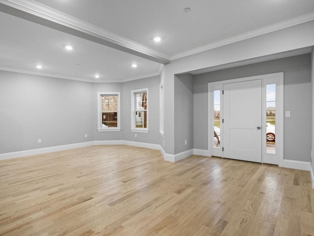 foyer entrance with plenty of natural light, ornamental molding, and light hardwood / wood-style flooring