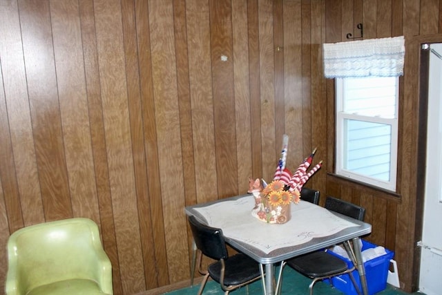 dining space featuring wood walls