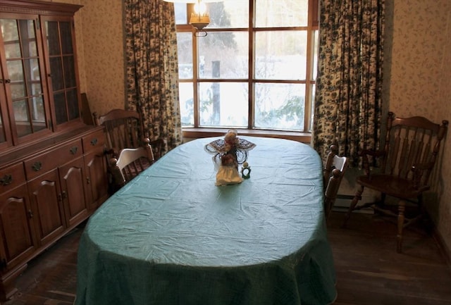 dining space featuring wallpapered walls and dark wood-style flooring