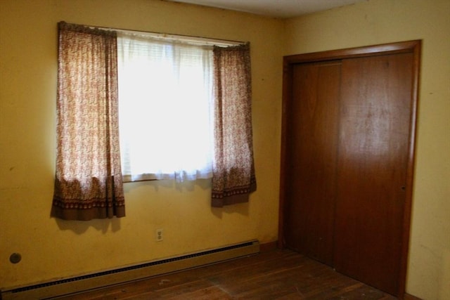 interior space featuring baseboard heating and wood finished floors