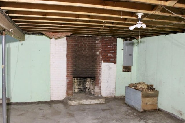 unfinished basement featuring a brick fireplace and electric panel