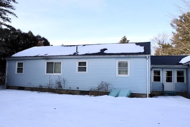 view of snow covered back of property