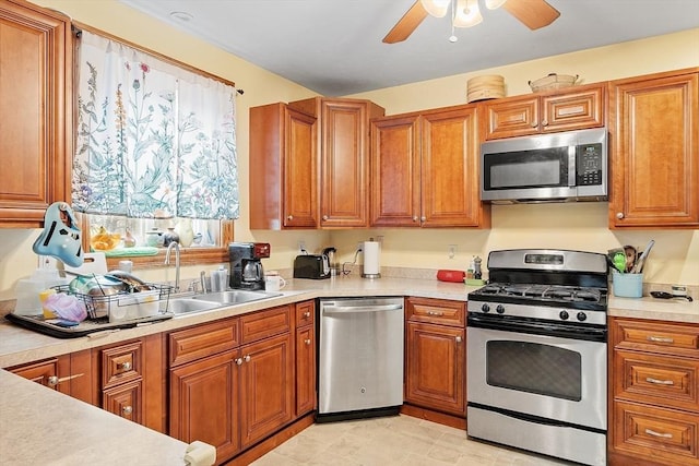 kitchen featuring a ceiling fan, brown cabinets, light countertops, and appliances with stainless steel finishes