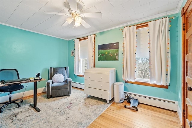 interior space featuring a baseboard heating unit, ornamental molding, and a healthy amount of sunlight