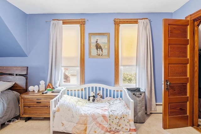 bedroom with light carpet and multiple windows
