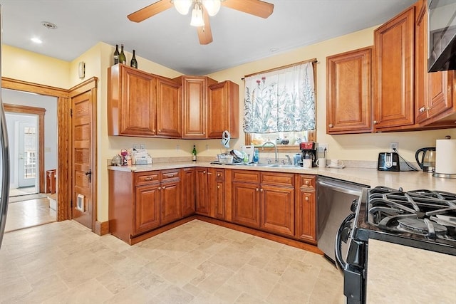 kitchen with stainless steel dishwasher, black gas range, brown cabinetry, and a sink