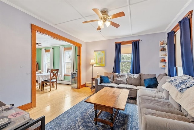 living room with light wood-style floors, baseboards, a ceiling fan, and a baseboard heating unit