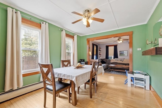 dining space featuring crown molding, light wood-style floors, and a ceiling fan