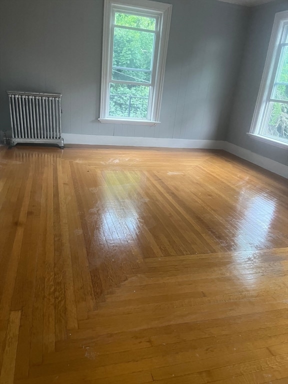 spare room featuring wood-type flooring and radiator heating unit