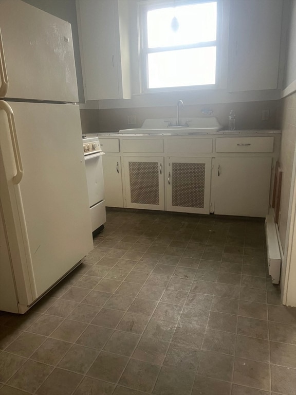 kitchen featuring white cabinets, white appliances, baseboard heating, and sink