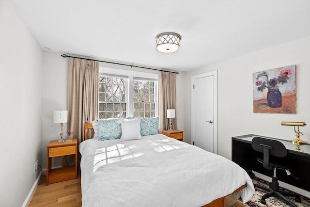 bedroom featuring light wood-style floors and baseboards