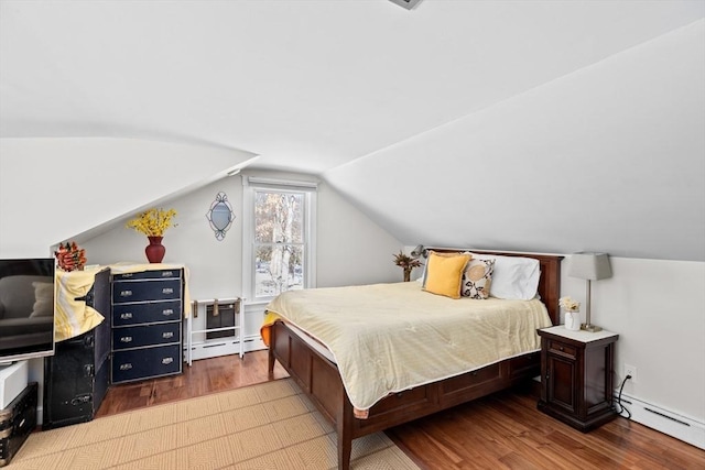 bedroom with a baseboard radiator, lofted ceiling, and wood finished floors