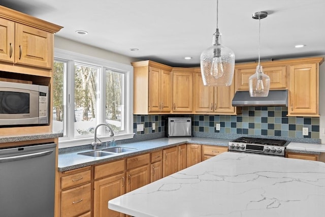 kitchen with decorative light fixtures, stainless steel appliances, a wealth of natural light, a sink, and wall chimney exhaust hood