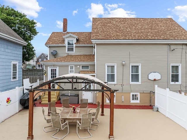 39 Crapo St, New Bedford, MA 02740 - back of property featuring roof with shingles, a patio area, a jacuzzi, and a chimney