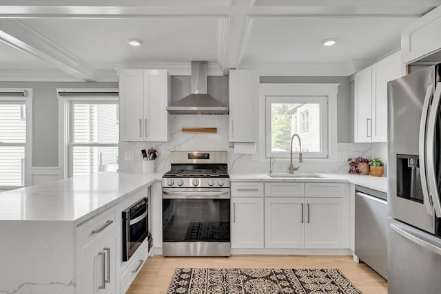 27 Central Rd Unit 1, Somerville, MA 02143 - kitchen featuring appliances with stainless steel finishes, wall chimney exhaust hood, a sink, ornamental molding, and a peninsula