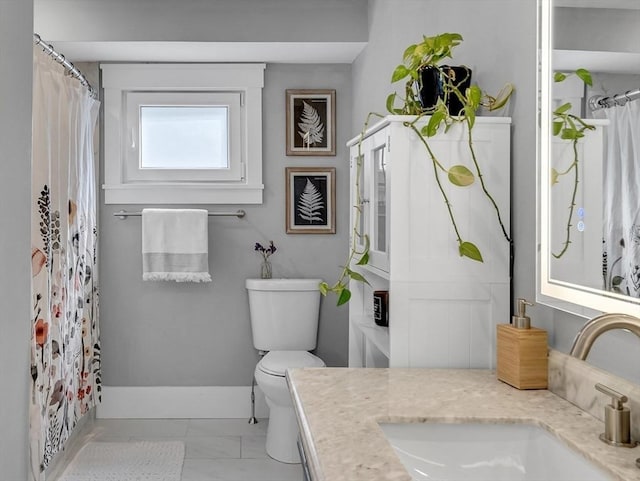 27 Central Rd Unit 1, Somerville, MA 02143 - bathroom featuring vanity, toilet, marble look tiles, and baseboards