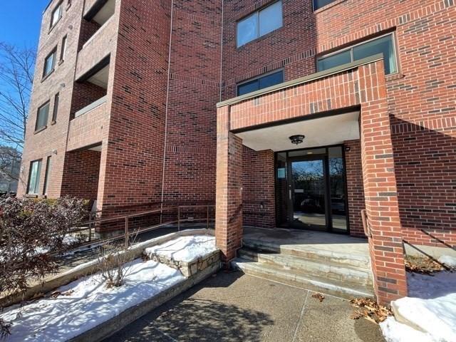 51 John St Unit 201, Brookline, MA 02446 - snow covered property entrance with brick siding