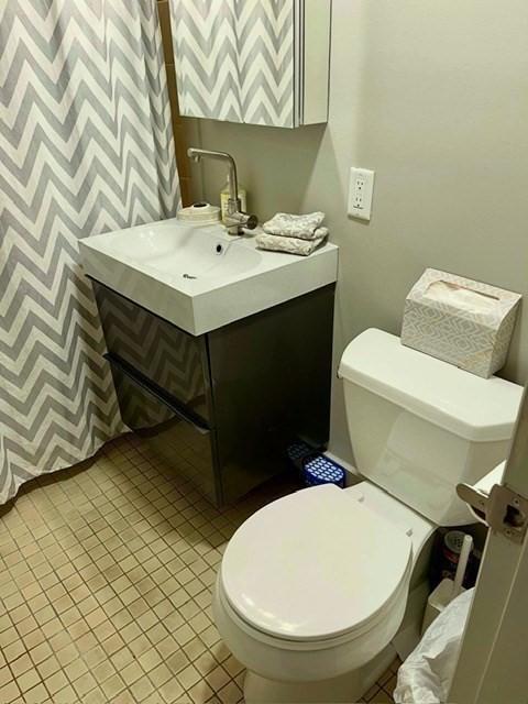 51 John St Unit 201, Brookline, MA 02446 - half bath with wallpapered walls, vanity, and tile patterned flooring
