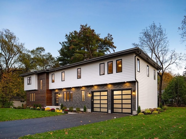 view of front of house featuring a garage and a front lawn