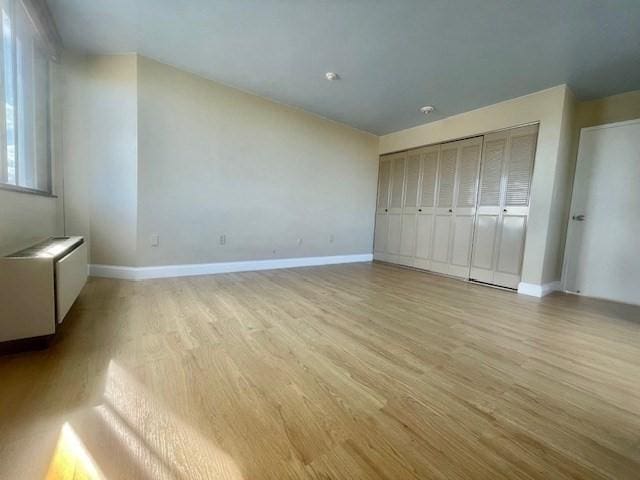 unfurnished bedroom with light hardwood / wood-style floors and a closet