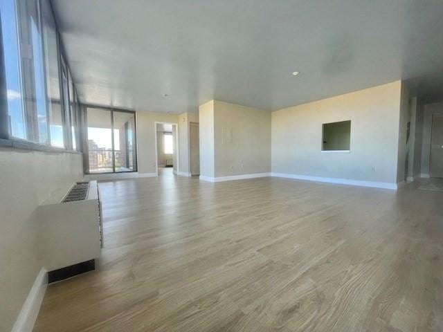 unfurnished living room with hardwood / wood-style flooring and a wall of windows