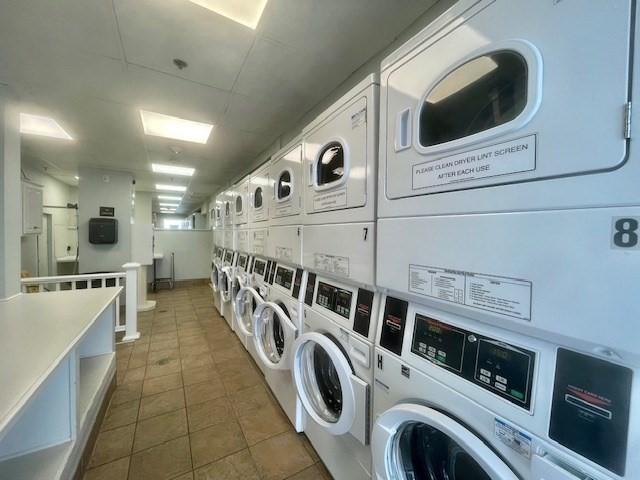 washroom with stacked washer and dryer and independent washer and dryer