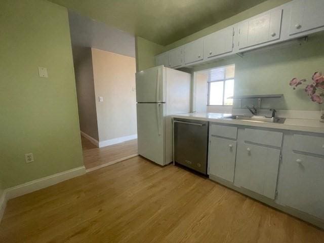 kitchen with dishwasher, sink, white refrigerator, light hardwood / wood-style floors, and white cabinets