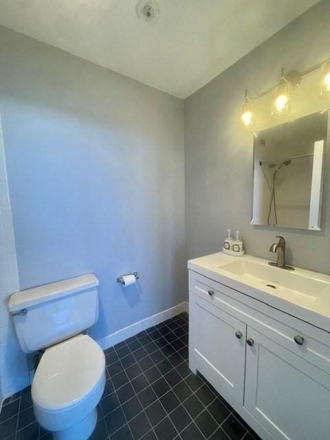 bathroom featuring vanity, toilet, and walk in shower