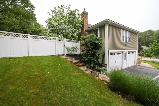 10 Morgan Cir, Holden, MA 01520 - view of property exterior featuring a chimney, asphalt driveway, and an attached garage