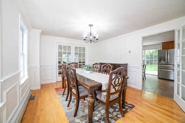 10 Morgan Cir, Holden, MA 01520 - dining room featuring a chandelier, a decorative wall, wainscoting, crown molding, and light wood-style flooring