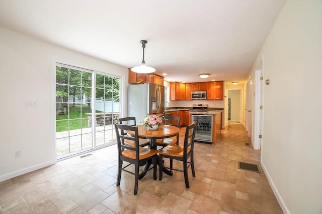 10 Morgan Cir, Holden, MA 01520 - dining space featuring stone tile flooring, baseboards, and wine cooler