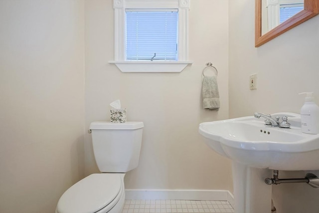 bathroom featuring baseboards and toilet