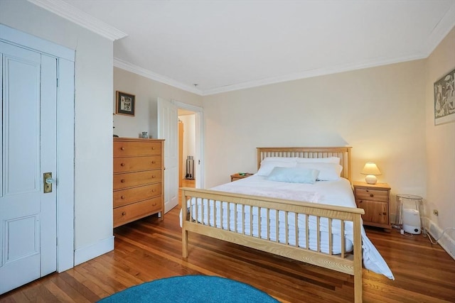 bedroom featuring crown molding, wood finished floors, and baseboards