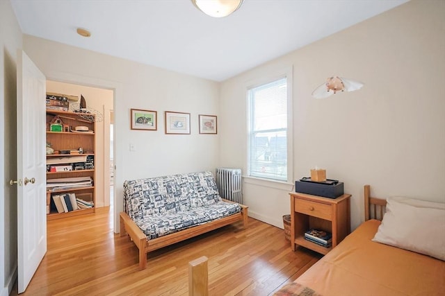 bedroom featuring light wood finished floors and radiator