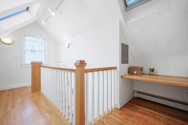 bonus room featuring a baseboard heating unit, baseboards, vaulted ceiling, electric panel, and wood finished floors