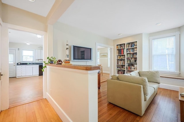 living area with recessed lighting, baseboards, and light wood finished floors