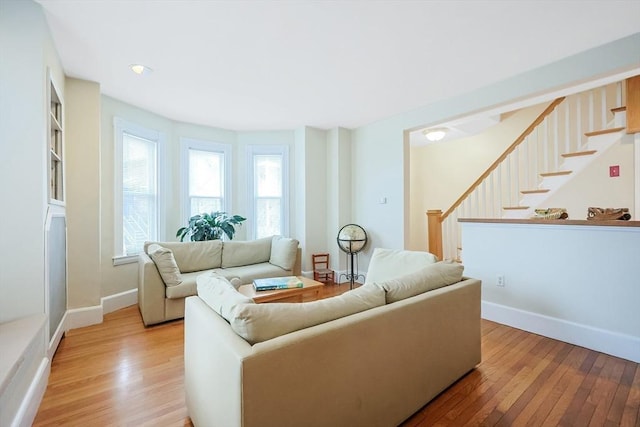 living room with light wood finished floors, stairway, and baseboards