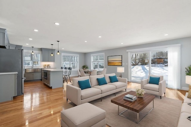 living area with recessed lighting, baseboards, and light wood finished floors