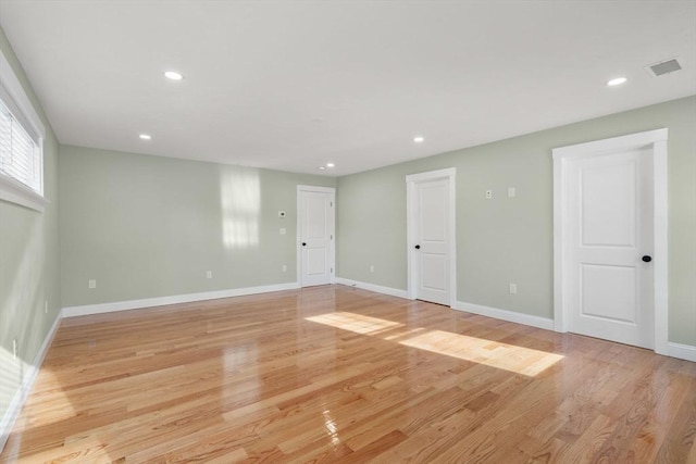 empty room featuring recessed lighting, light wood-type flooring, visible vents, and baseboards