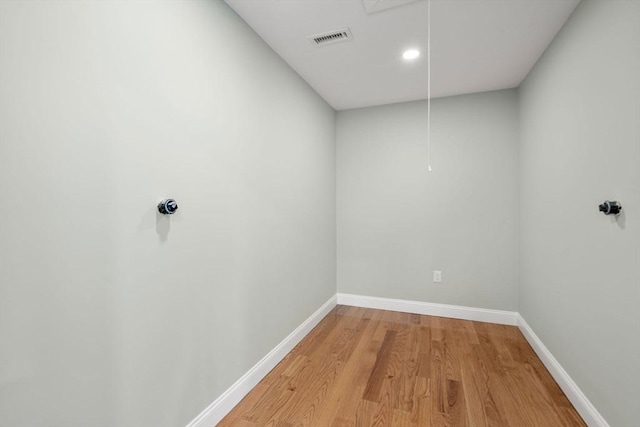 interior space with attic access, visible vents, baseboards, and wood finished floors